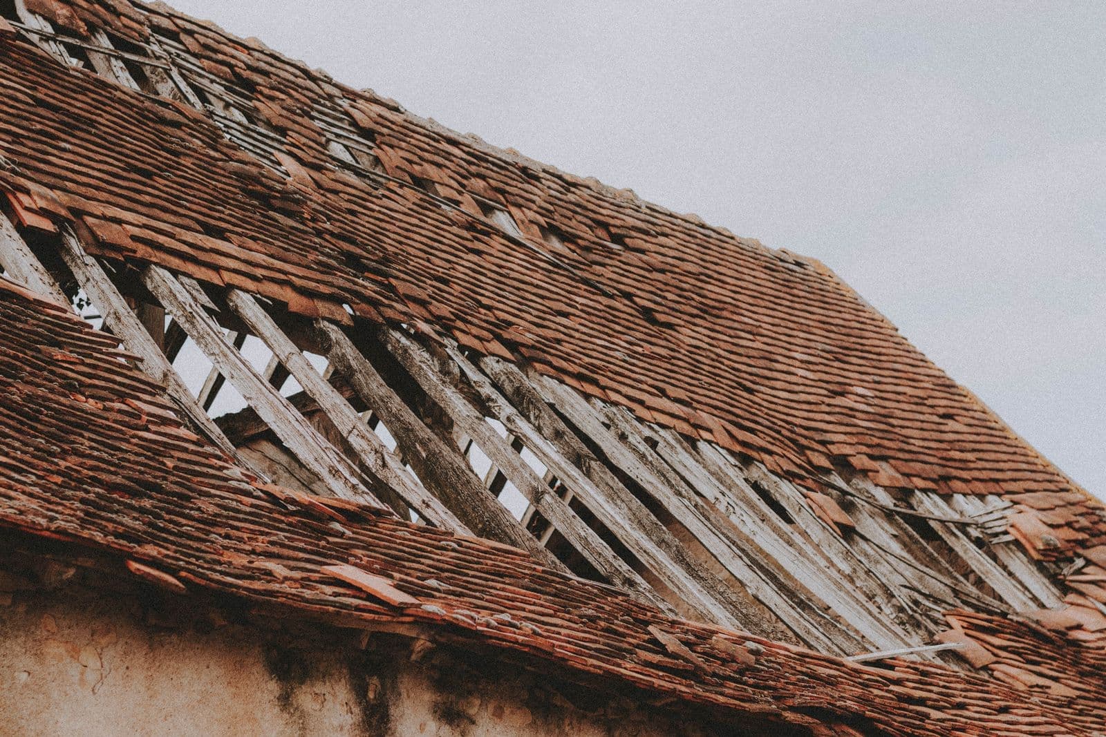 Damaged roof with missing shingles exposing the wood battens